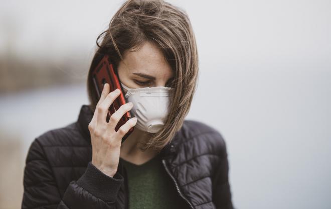 Femme au téléphone portant un masque de protection